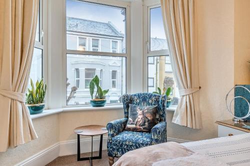 a bedroom with a chair and a window at Mariners Guest House in Plymouth