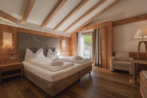 a bedroom with a large bed and a window at Hotel Emmy - five elements in Völs am Schlern