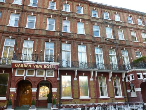 a large brick building with a clock on the front of it at Garden View Hotel in London