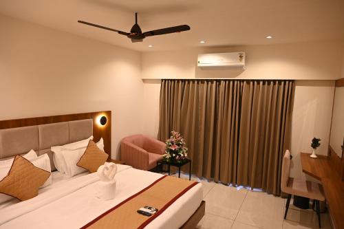 a hotel room with a bed and a desk at Good One Suites Near Manyata Tech Park in Bangalore