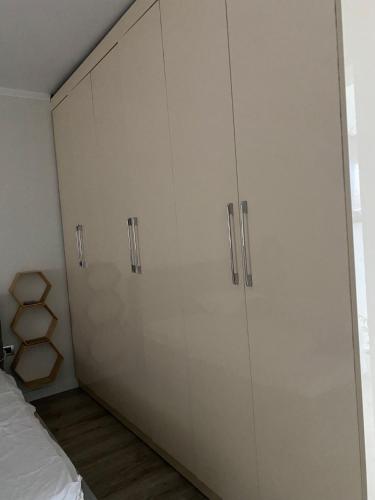 a room with two white cabinets and a bed at Redi Apartment Center in Elbasan