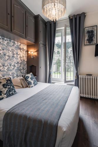 a bedroom with a large bed and a window at Le Bretagne - Hôtel de charme labellisé Cosy Places in Vannes