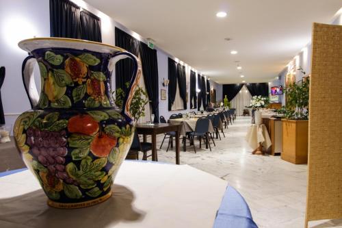 a colorful vase sitting on a table in a restaurant at Miramare Hotel in Catania