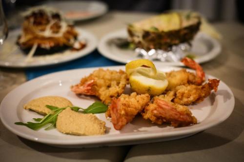 a plate of food on a table with plates of food at Miramare Hotel in Catania