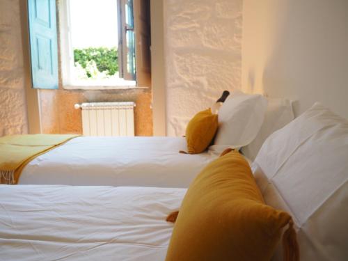 two white beds in a room with a window at Quinta da Coutada - AgroTurismo in Arcos de Valdevez