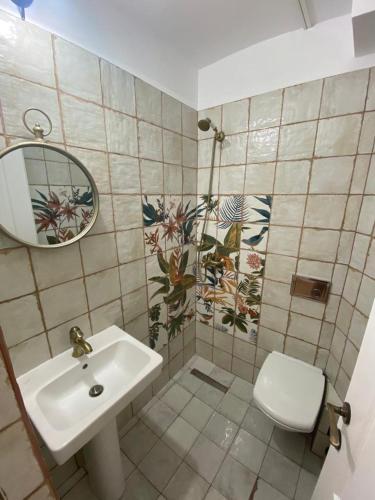 a bathroom with a sink and a toilet and a mirror at Glam Boutique in Mangalia