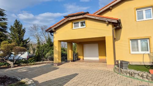 a yellow house with a garage at MaMa Apartment in Seredʼ