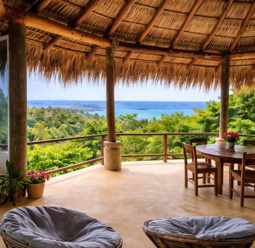 a patio with a table and chairs and a view of the ocean at Villa Luna de Miel in Mazunte