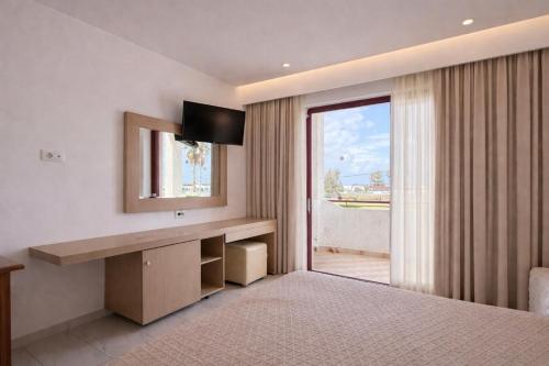 a bedroom with a bed and a mirror and a window at Golden Sun in Tigaki