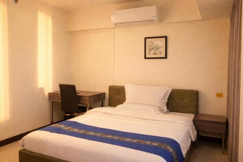 a hotel room with a bed and a desk and a laptop at Extremeli Suites in Manila