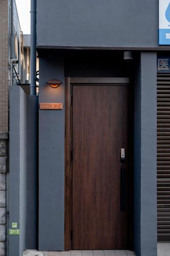 a brown door on a building with a sign on it at Edo stay senju in Tokyo