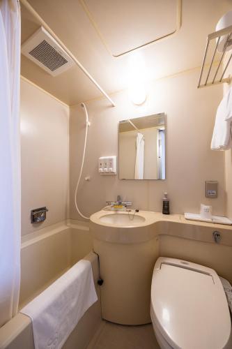 a bathroom with a toilet and a sink at ホテルグランフォーレ in Shikokuchuo