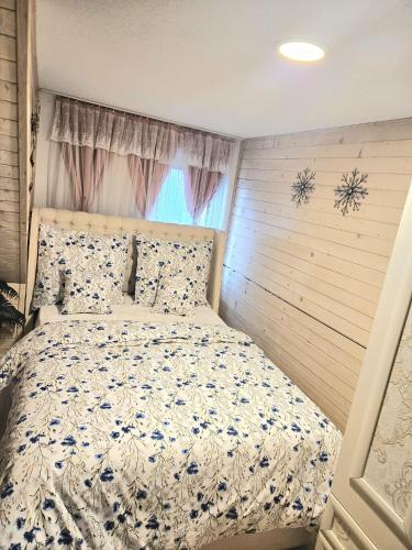 a bedroom with a bed with a blue and white comforter at Vila Vannet II in Liptovský Mikuláš