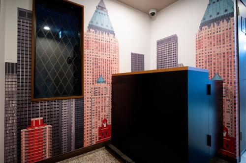 a room with a mural of buildings on the wall at Edo stay senju in Tokyo