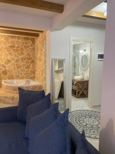 a room with a blue couch and a bathroom with a tub at Villa Magiko in Poros