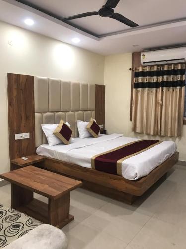 a bedroom with a large bed and a table at Hotel Priya Palace in Rānchī