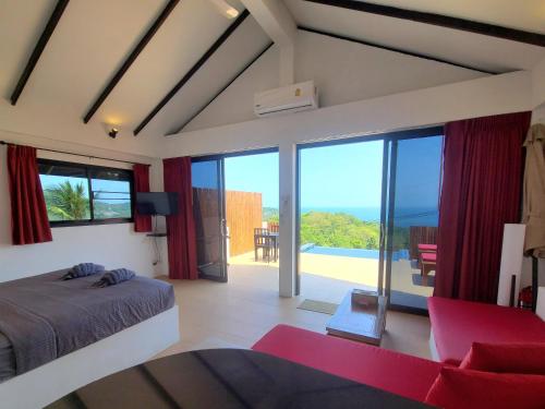 a bedroom with a bed and a view of the ocean at Karo Villas in Ko Tao
