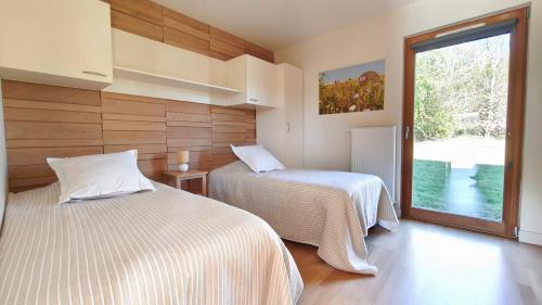 two beds in a room with a window at Les Woodies in Xertigny