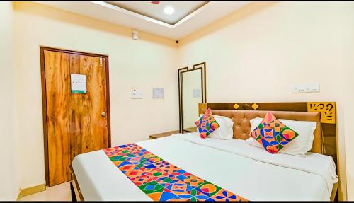 a bedroom with a large bed and a wooden door at Hotel Qness in Hyderabad