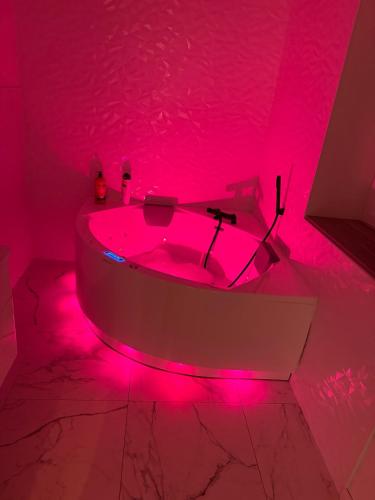 a bathroom with a pink lighted tub in a room at La Maison De Parrain in Kerlouan