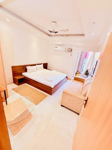a bedroom with a bed and a couch and a window at Airport Sky Transit Suites in Rānchī