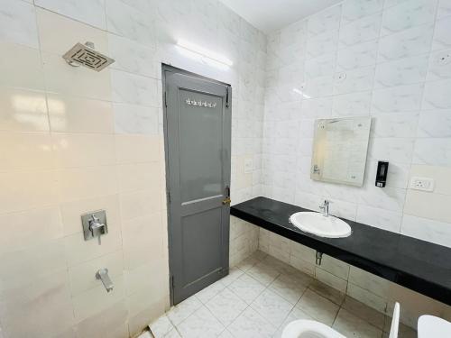 a bathroom with a toilet and a sink and a door at Traditional villa in Gurgaon