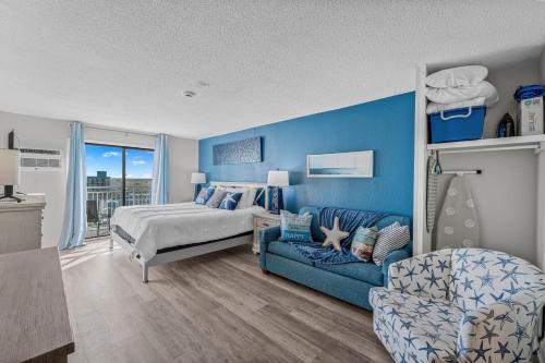 a blue bedroom with a bed and a couch at Beach View Condo in Myrtle Beach