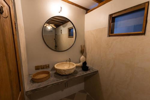 a bathroom with a sink and a mirror at The Swan Villa in Gili Trawangan