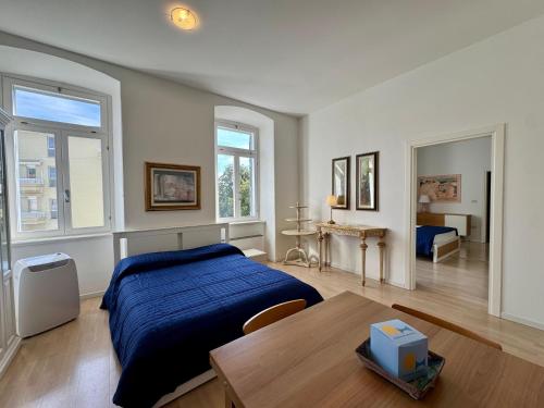 a bedroom with a bed and a table and windows at Villa Ercole in Grado