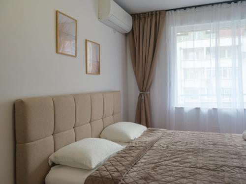 a bedroom with a large bed and a window at Shazam Apartment Central, Stylish & Cozy near AUBG in Blagoevgrad