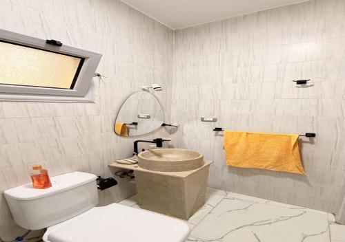 a white bathroom with a toilet and a mirror at Eshyan Guest House in Aswan
