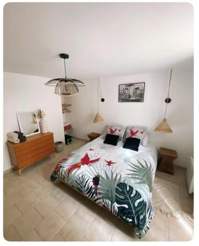 a bedroom with a bed with a tropical bedspread at Gîte de charme au pied du Château de Brissac in Brissac