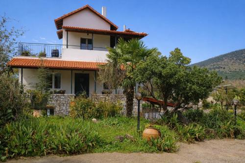 a house with a palm tree in front of it at Villa Dorothy - Mountain View Retreat, Polydrosos in Delphi