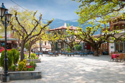 a town square with tables and chairs and trees at Villa Dorothy - Mountain View Retreat, Polydrosos in Delphi