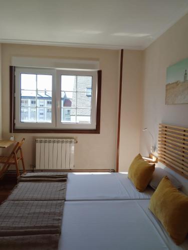 a bedroom with a large bed and a window at Pensión 813 in Palas de Rei