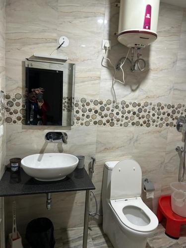 a bathroom with a toilet and a sink and a mirror at Dadhwal B&B in Dharmsāla