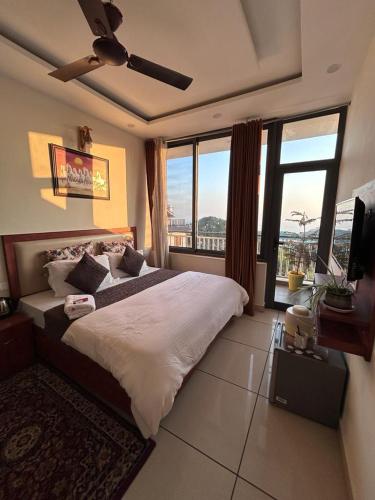 a bedroom with a large bed and large windows at Dadhwal B&B in Dharmsāla