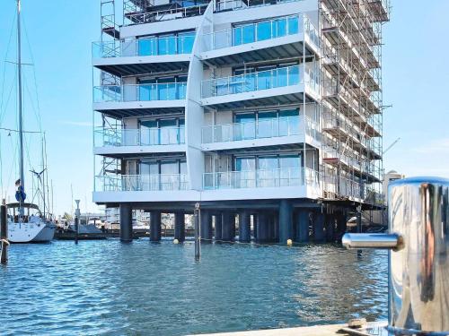 a large building on the water next to a marina at 5 star holiday home in Wendtorf in Wendtorf