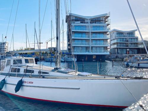 a white boat docked in the water with a building at 5 star holiday home in Wendtorf in Wendtorf