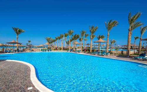 una piscina en un complejo con palmeras en Hawaii Riviera Aqua Park Resort - Families and Couples Only, en Hurghada
