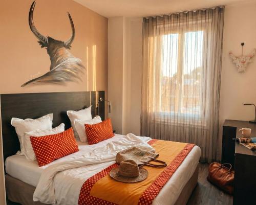 a bedroom with a bed with a hat on it at Hotel Saint Louis - Au Coeur des Remparts in Aigues-Mortes