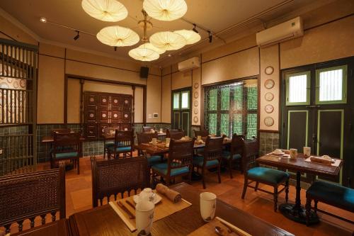 a restaurant with wooden tables and chairs and lights at Solaria Hanoi Hotel in Hanoi