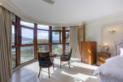 a bedroom with a bed and a table and chairs at Villa Visanty with Private Pool & Access to Beach in Aigosthena