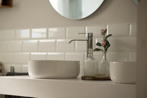 a bathroom counter with two white sinks and a mirror at A Casiña dos Veiras - 3Km antes de Bruma in Santa Eulalia