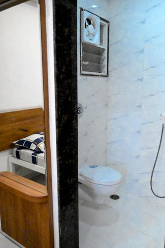 a small bathroom with a toilet and a sink at Laxman AC Lodge Jejuri - by Martandbhairav hospitality LLP in Jejūri