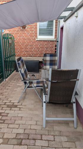 two chairs sitting under an umbrella on a patio at Ferienwohnung Rumbeck in Hessisch Oldendorf