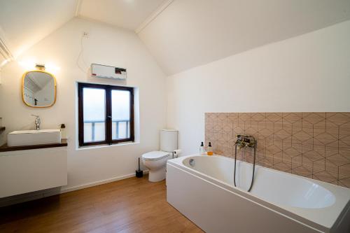 a bathroom with a bath tub and a toilet at Le Cocon Alsacien Parking privé Espace repas BBQ in Ebersheim