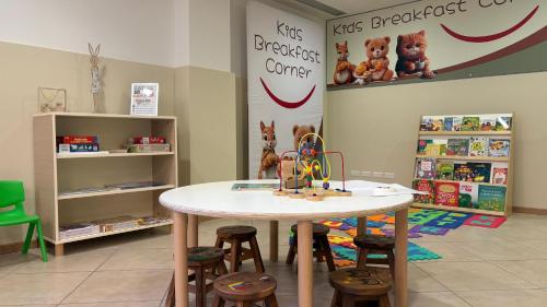 a table and stools in a room with a table and chairs at Kairos Garda Hotel in Castelnuovo del Garda