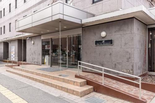 a building with steps in front of a store at Ace Inn Matsumoto in Matsumoto
