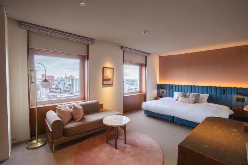 a hotel room with a bed and a couch at The Mark Grand Hotel in Saitama